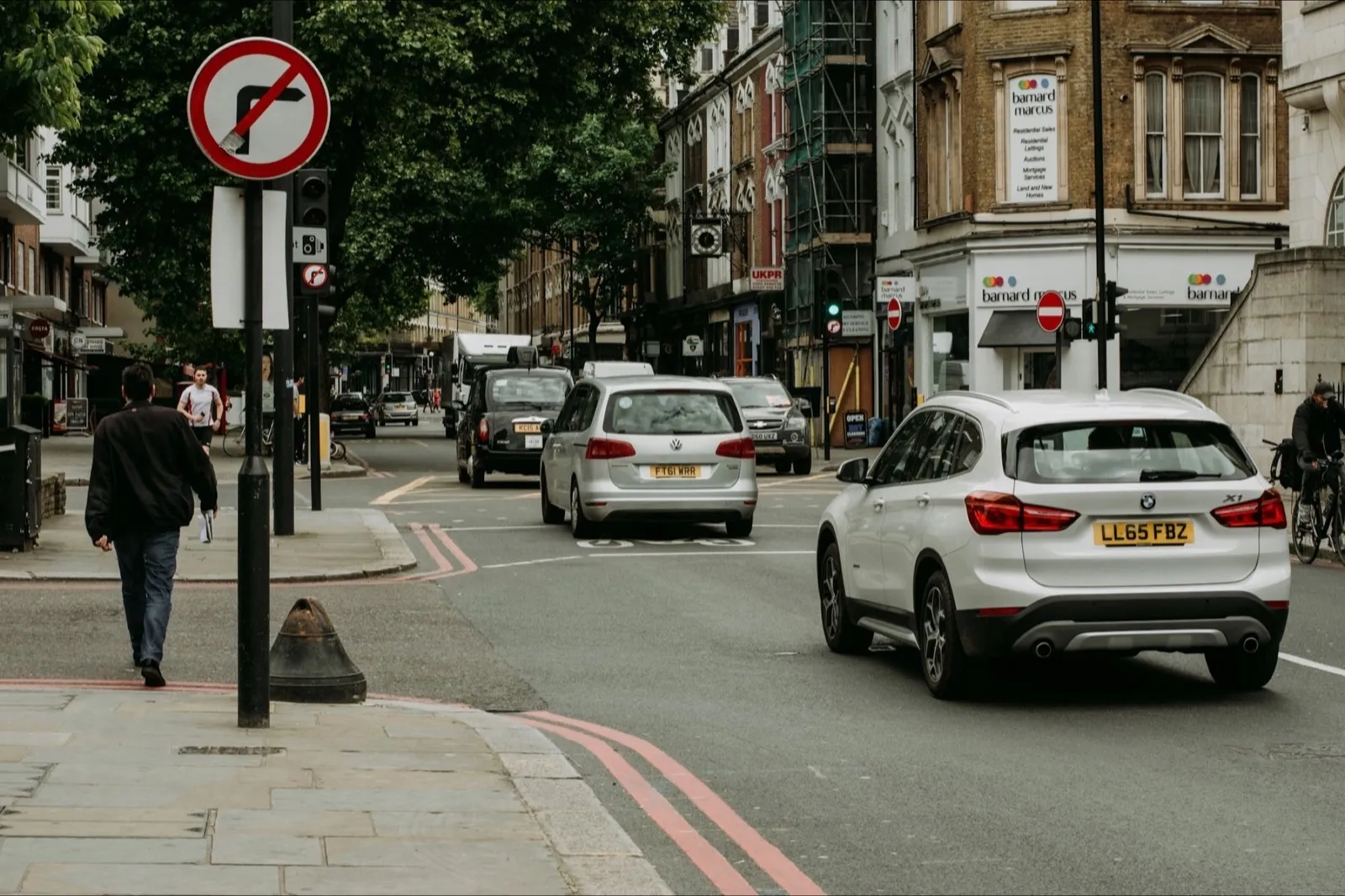 A no right turn sign at a London junction with red route lines