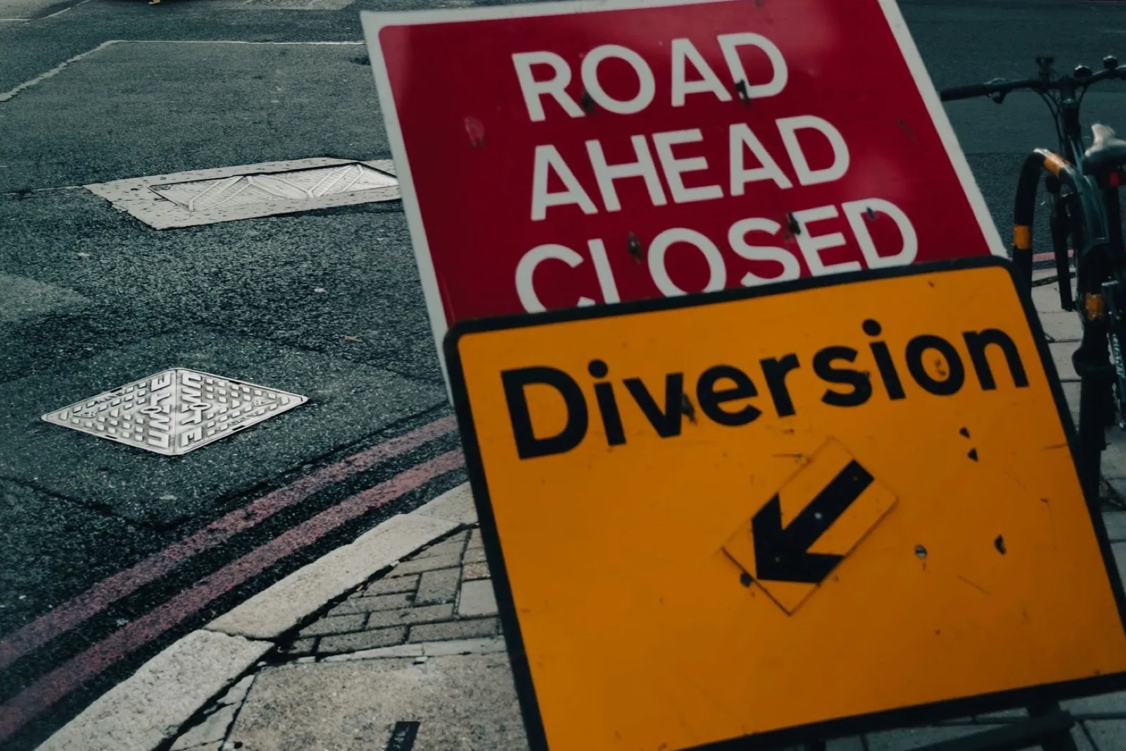 'Road ahead closed' sign with a yellow 'Diversion' arrow on a London street