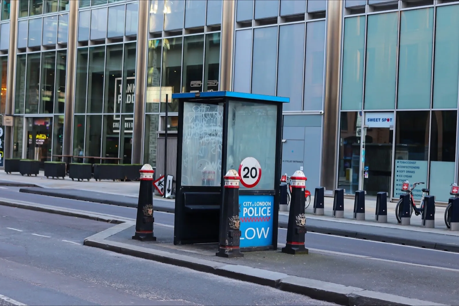 A City of London street with a 20 mph roundel displayed by a police box